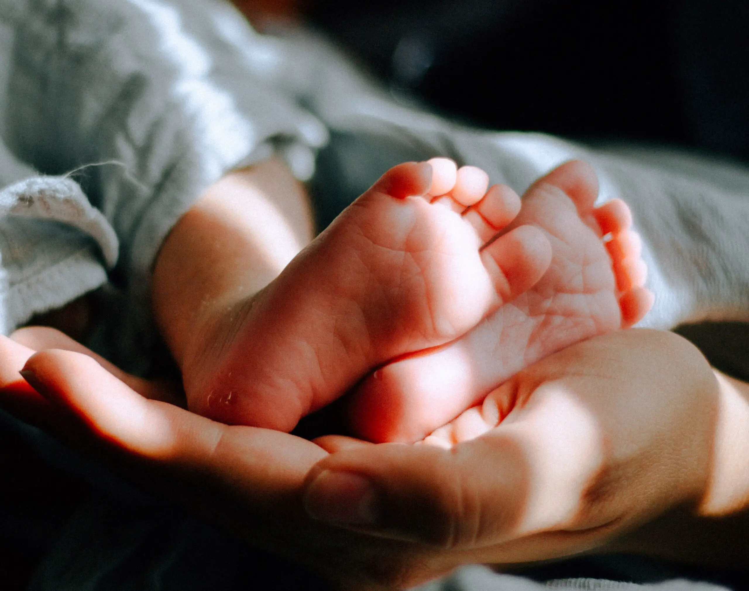 baby feet held by adult